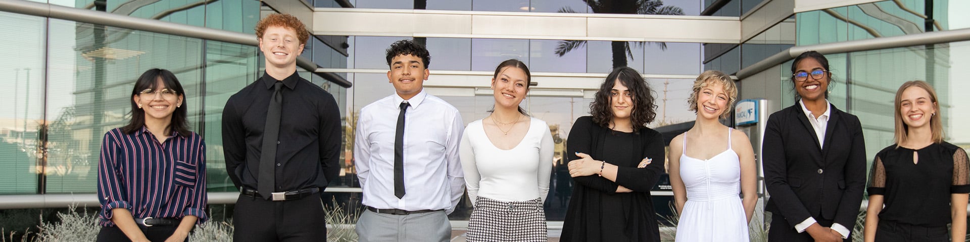 Eight students who have been awarded scholarships from Desert Financial stand proudly in a row, lined up in front of the headquarters at Papago. Eight students who have been awarded scholarships from Desert Financial stand proudly in a row, lined up in front of the headquarters at Papago.