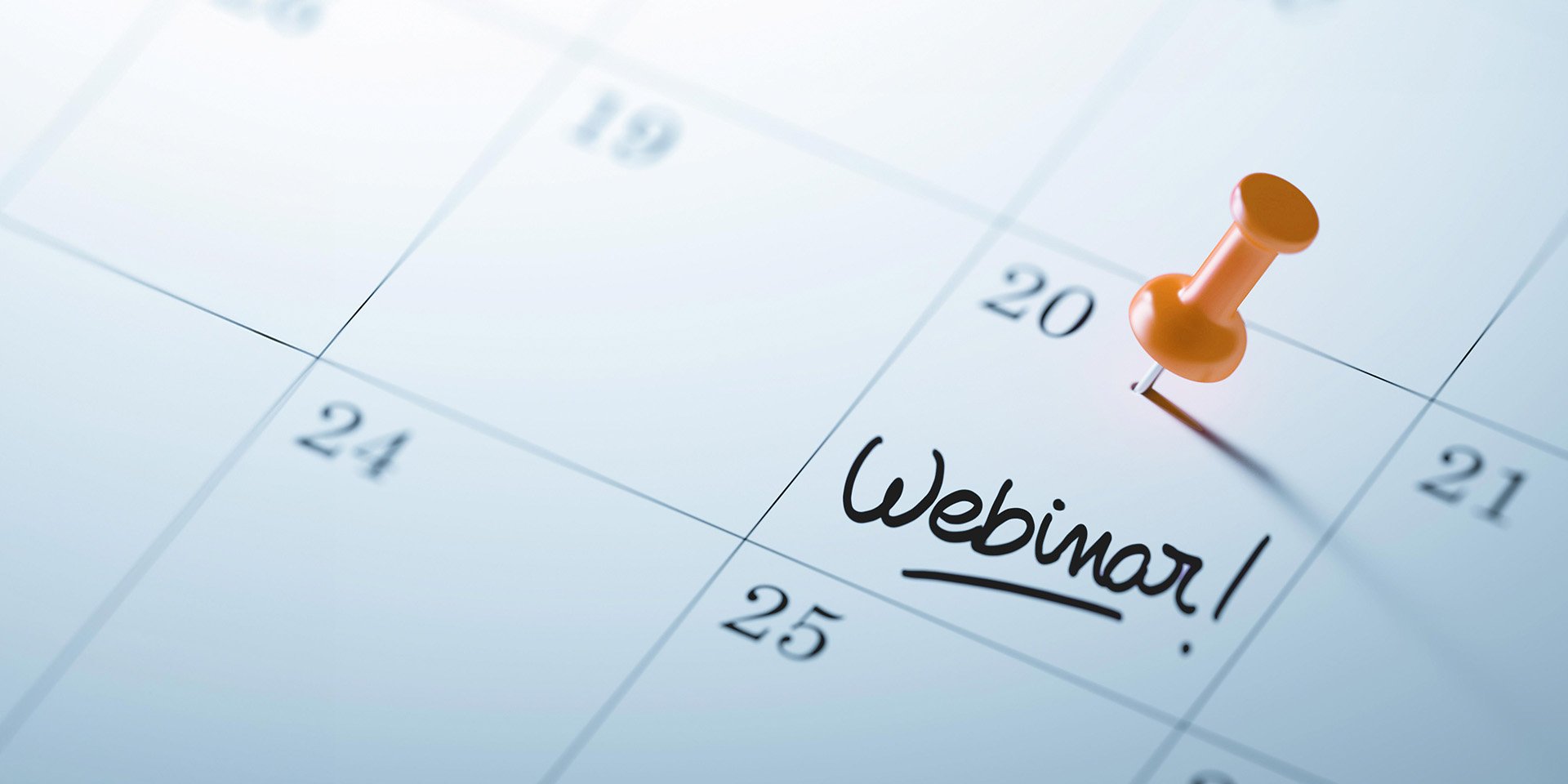 Zoomed-in picture of a calendar highlighting the 20th with an orange tack, featuring the word 'Webinar!' written across the square.