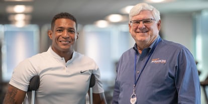 Anthony Robles (left) and Jeff Meshey (right) smiling for the camera in the office as they celebrate Robles' new role as spokesperson for Desert Financial Credit Union. 