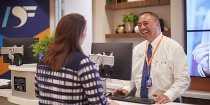A cheerful Desert Financial Experience Specialist providing assistance to a member with a warm smile in one of the welcoming branches across Arizona, creating a positive and helpful banking experience.