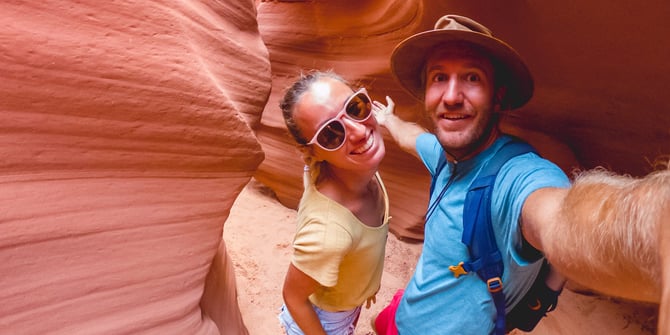 Two happy hikers taking a selfie at the bottom of a canyon. 
