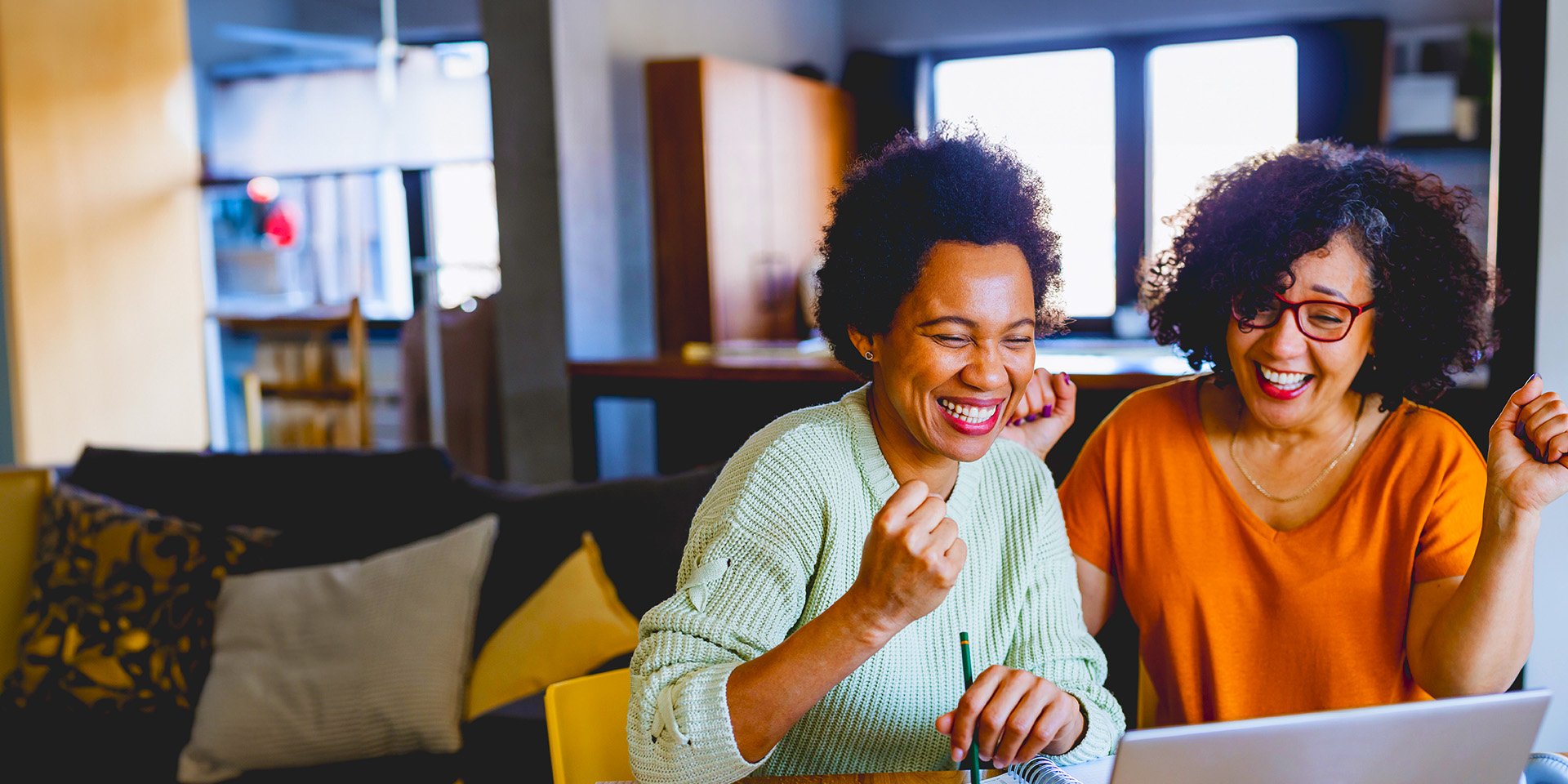 Two excited ladies on the Desert Financial website learning how to grow their savings.