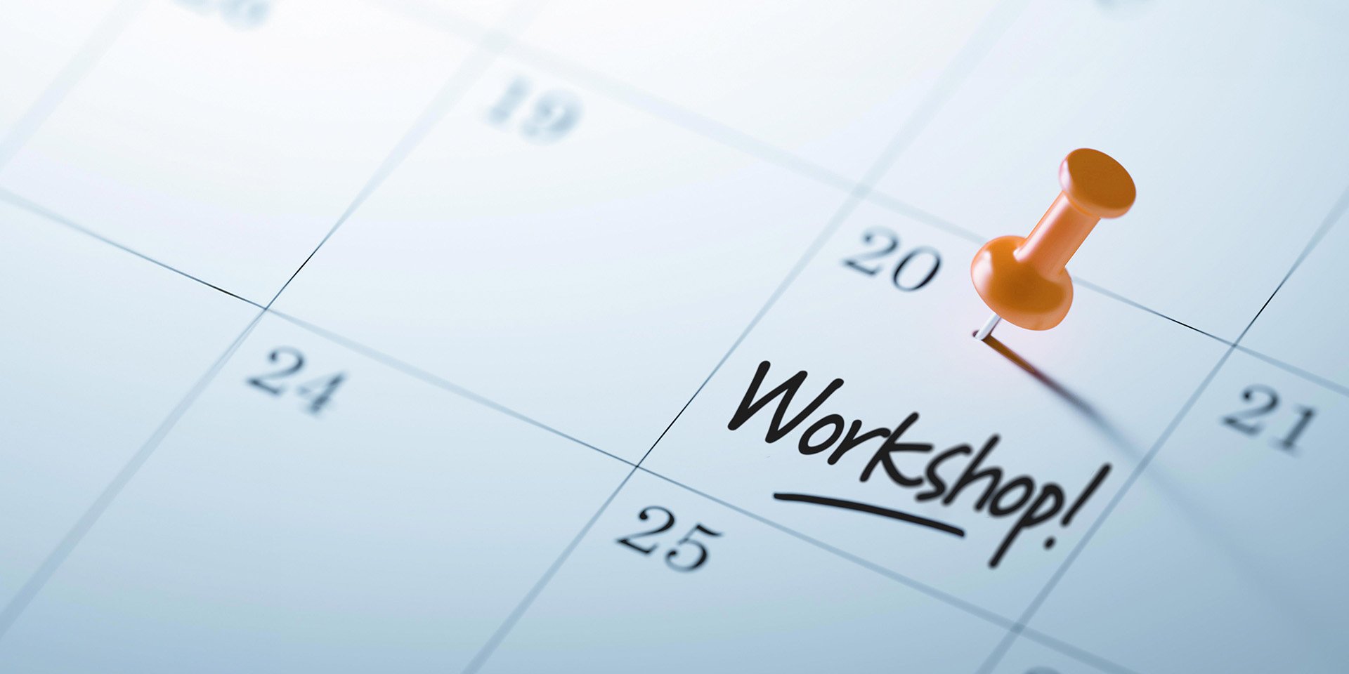 Zoomed-in picture of a calendar highlighting the 20th with an orange tack, featuring the word 'Workshop!' written across the square. Zoomed-in picture of a calendar highlighting the 20th with an orange tack, featuring the word 'Workshop!' written across the square.